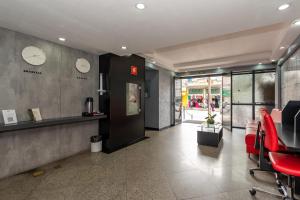 an office with red chairs and clocks on the wall at Metropolitan Flats in Curitiba