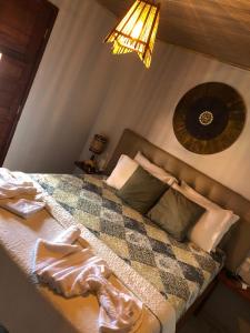 een slaapkamer met een bed met een deken erop bij Casa Milagres do Porto - Suítes in São Miguel dos Milagres