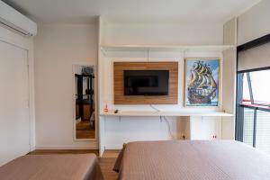 a bedroom with two beds and a flat screen tv at Bristtol Metropolitan Flat in Curitiba