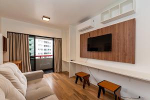 Bristtol Metropolitan Flat في كوريتيبا: غرفة معيشة مع أريكة وتلفزيون