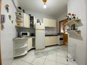 uma cozinha com um frigorífico e um micro-ondas em B127- Apto Vista Mar p/ 9 pessoas em Bombinhas SC em Bombinhas
