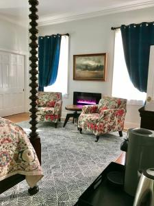ein Wohnzimmer mit 2 Stühlen und einem Tisch in der Unterkunft Charred Oaks Inn in Versailles