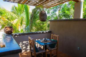 a blue table and chairs on a patio with palm trees at Pure Baja Suites and Retreats - Single Rooms in El Pescadero