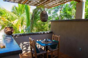 a blue table and chairs on a patio with palm trees at Pure Baja Private Suites-Upscale Property with Infinity Pool and Lush Gardens in El Pescadero