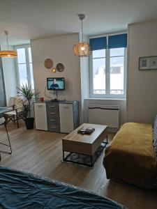 a living room with a couch and a coffee table at Appartement "La Marine" vue mer in Saint-Pair-sur-Mer