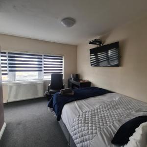 sypialnia z łóżkiem, biurkiem i telewizorem w obiekcie The Beath Inn w mieście Cowdenbeath