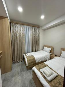 White Corner in Old Tbilisi في تبليسي: غرفة فندقية بسريرين ونافذة