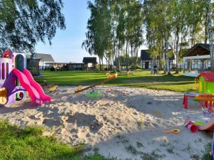 un parque infantil con juguetes en la arena en un parque en Two-story holiday house for 5 people, Jaroslawiec en Jarosławiec