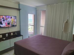 um quarto com uma cama roxa e uma televisão em Edificio,Terraço do Atlantico, 2 quartos, 2 banhos, no Aterro da Praia de Iracema em Fortaleza
