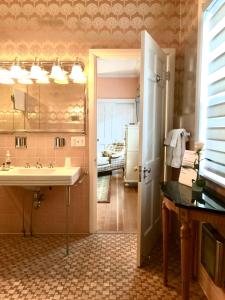 y baño con lavabo y nevera. en Charred Oaks Inn en Versailles