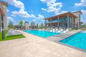 a swimming pool with chairs and a building at Stunning 1BD apt in Fort Worth