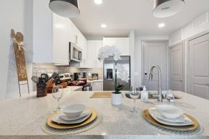 a kitchen with a counter with plates and wine glasses at Stunning 1BD apt in Fort Worth