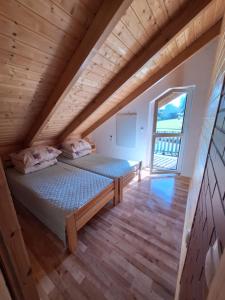 a bedroom in a log cabin with a bed and a window at Domki Nad Liliowym Stawem in Berezka