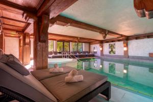 a swimming pool with two towels on a couch next to it at Golf & Alpin Wellness Resort Hotel Ludwig Royal in Oberstaufen