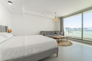 a bedroom with a bed and a couch and a table at Sea Side Eilat Vacation Apartment in Eilat