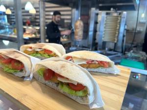 tres sándwiches sentados en un mostrador en un restaurante en Casa Rustic cazare, en Piteşti