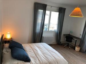 een slaapkamer met een bed, een bureau en een raam bij Maison confortable et calme/5 chambres & 6 SdB in Toulouse