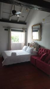 um quarto com uma cama e um sofá vermelho em EMMA HOTEL SAN DIEGO em Cartagena das Índias