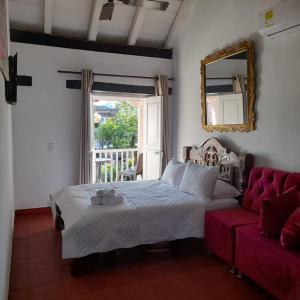 a bedroom with a bed and a red couch at EMMA HOTEL SAN DIEGO in Cartagena de Indias