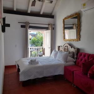 ein Schlafzimmer mit einem Bett und einem roten Sofa in der Unterkunft EMMA HOTEL SAN DIEGO in Cartagena de Indias