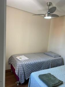een kamer met 2 bedden en een plafondventilator bij NPousadas in Belo Horizonte