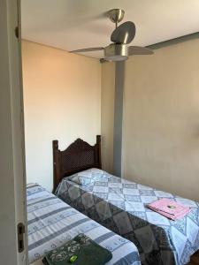 een slaapkamer met 2 bedden en een plafondventilator bij NPousadas in Belo Horizonte