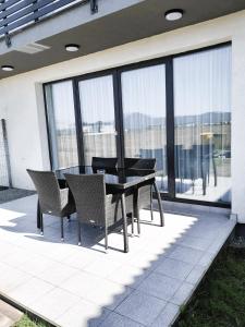 a black table and chairs on a patio with windows at Casa Beaumont Cristian in Cristian