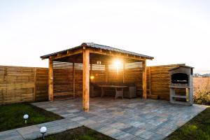 een houten paviljoen met een tafel en een grill bij Casa Beaumont Cristian in Cristian