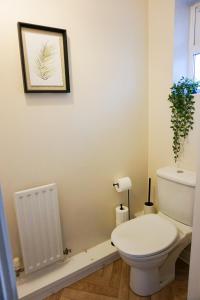 a bathroom with a toilet and a picture on the wall at Oak House - Spacious Townhouse, FREE gated parking, perfect for corporate, contractor & Leisure guests in Bedford
