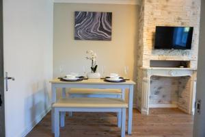 a table with two chairs and a tv on a wall at Oak House - Spacious Townhouse, FREE gated parking, perfect for corporate, contractor & Leisure guests in Bedford