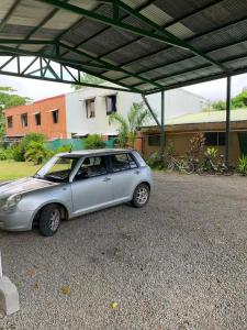 a small silver car parked under a roof at Casa Natalia in Herradura