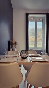 uma mesa de jantar com cadeiras e uma janela em La Suite Côté Parc (Superbe T2 classé 4*) em Saint-Martin-dʼUriage