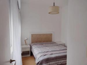 a small bedroom with a bed and a night stand at Depto Mar del Plata - Centro in Mar del Plata