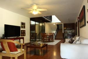 ein Wohnzimmer mit einem Sofa und einem TV in der Unterkunft DUPLEXU PANAMA Homestay in Panama-Stadt