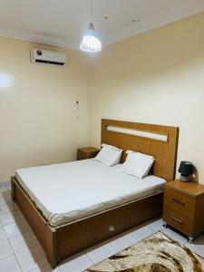 a bedroom with a large bed with white sheets at Ace Appartement Meublé in Nouakchott