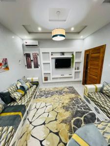 a living room with two couches and a flat screen tv at Ace Appartement Meublé in Nouakchott