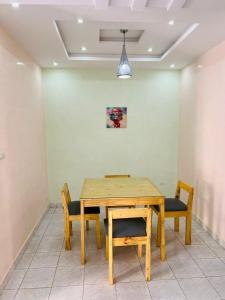 a dining room with a wooden table and chairs at Ace Appartement Meublé in Nouakchott