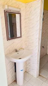 a bathroom with a white sink and a mirror at Ace Appartement Meublé in Nouakchott