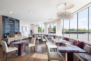 a restaurant with tables and chairs and windows at Sheraton Stockholm Hotel in Stockholm