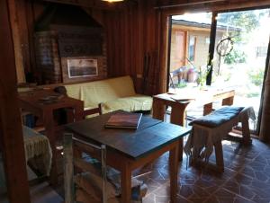 uma sala de estar com uma mesa e um sofá em Hostal Repu em Pucón