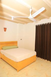 a bedroom with a bed and a ceiling fan at Elamier House in Al Aqālitah