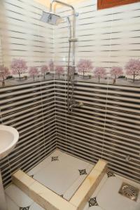 a bathroom with a shower with pink trees in the window at Elamier House in Al Aqālitah