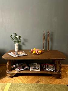 a wooden coffee table with a bowl of fruit on it at K-Apartment in Rīga