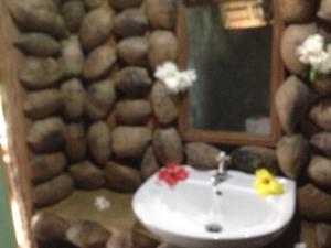a bathroom with a sink with a mirror and a mirror at Tanna Lava View Bungalows in Lénakel