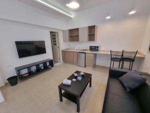 Downtown Living Boutique Apartments في عمّان: غرفة معيشة مع أريكة وطاولة ومطبخ