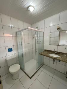 a bathroom with a shower and a toilet and a sink at Suites Brothers Centro in Búzios
