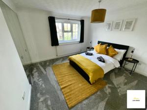 a bedroom with a bed with a yellow blanket and a window at Burnham/Sleep 10/Private Parking/Close to Heathrow in Burnham