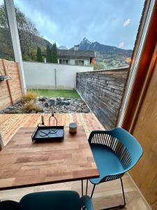 eine Terrasse mit einem Holztisch und 2 Stühlen sowie Aussicht in der Unterkunft Casa Cozy in Schruns-Tschagguns