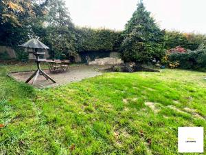 a garden with a bird feeder in the grass at Burnham/Sleep 10/Private Parking/Close to Heathrow in Burnham