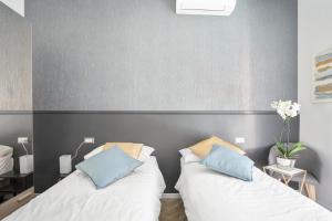 two beds sitting next to each other in a bedroom at MK - Apartment in Milan
